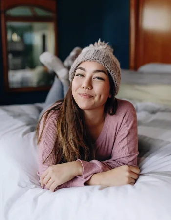 Annemarie Chase in winter annemari chase posing on a bed annd smiling